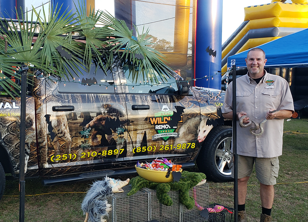 AAAC Wildlife Removal specialist holding a snake at a fair.